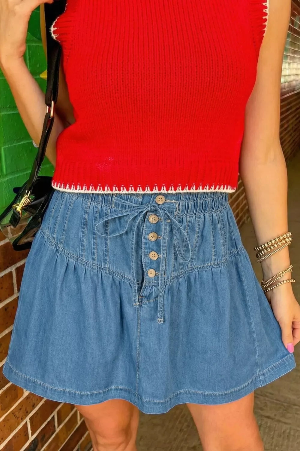 Charming ruffle hem denim skirt with button front and tie waist.