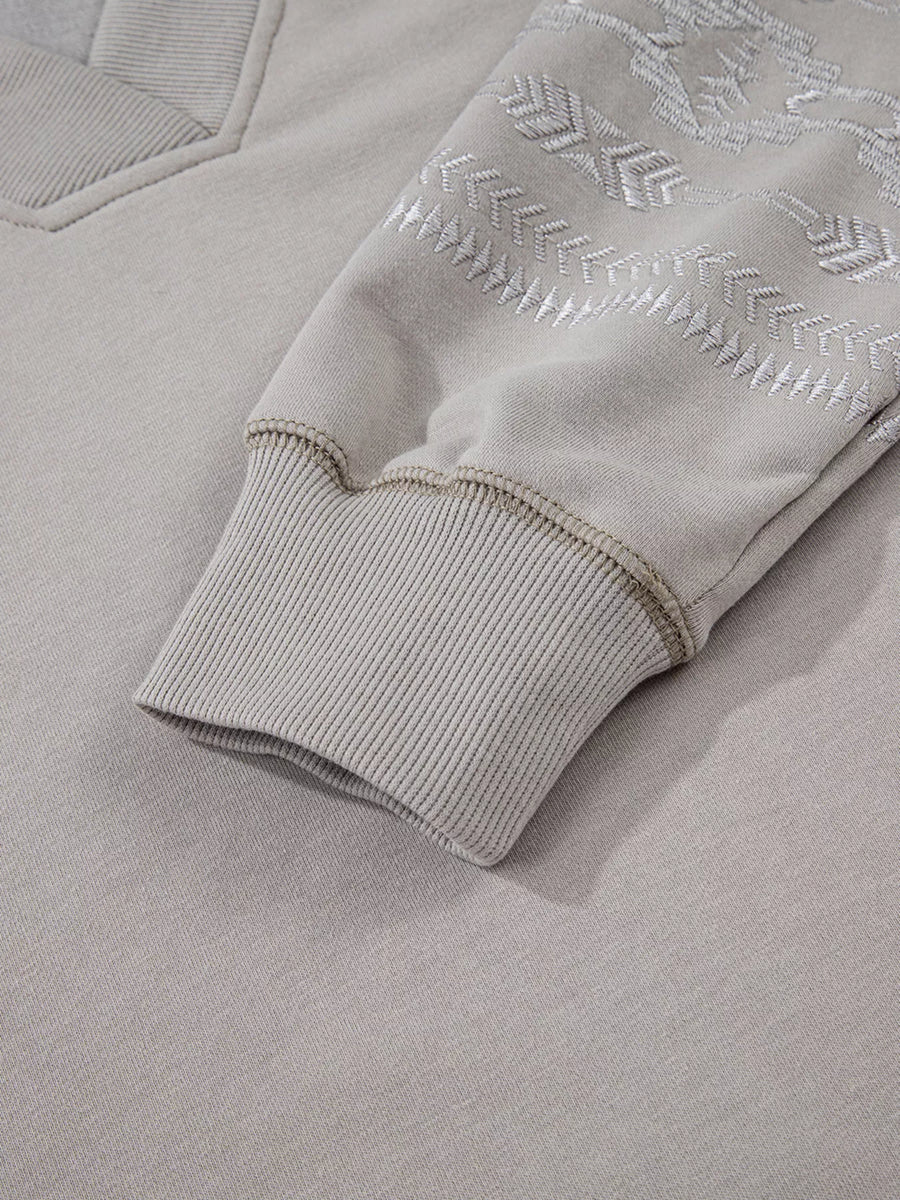 Gray V-neck sweatshirt with Aztec embroidery on the sleeve and ribbed cuffs.