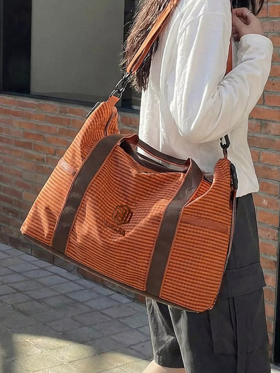 Large orange striped travel bag with brown trim and versatile straps