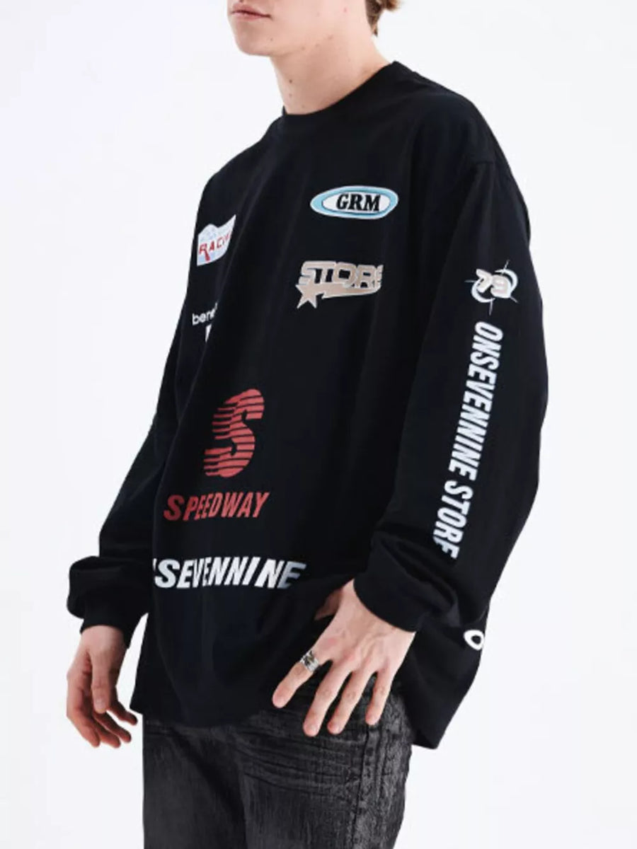 Black cotton long sleeve t-shirt with multiple graphic patches and text details.