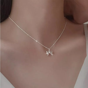 necklace in silver featuring bow charm and straight fit