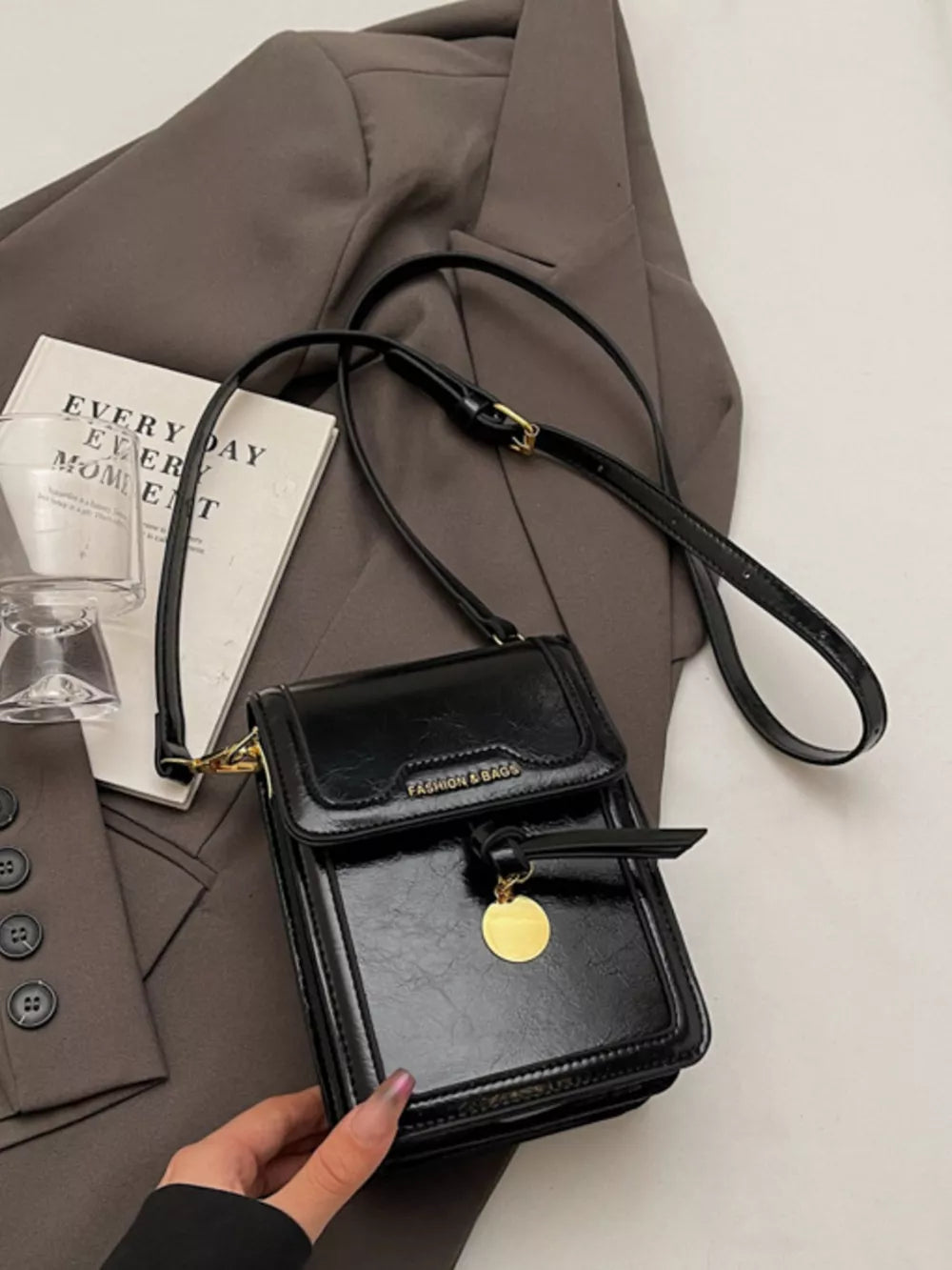 Black pu leather crossbody bag with gold charm and adjustable strap