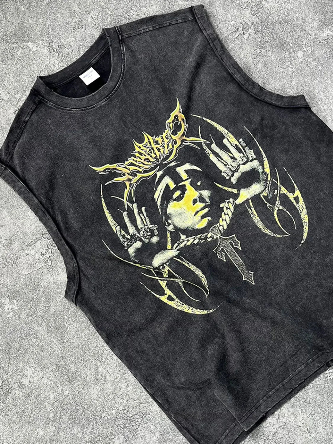 Black vintage wash graphic tank top with a yellow artistic print and a cross pendant.
