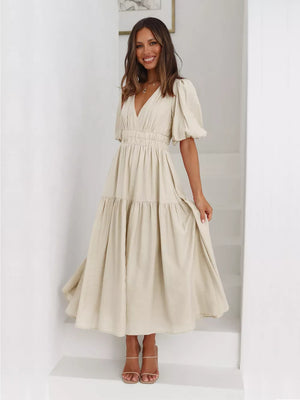Beige midi dress with puff sleeves, V-neck, and tiered skirt.