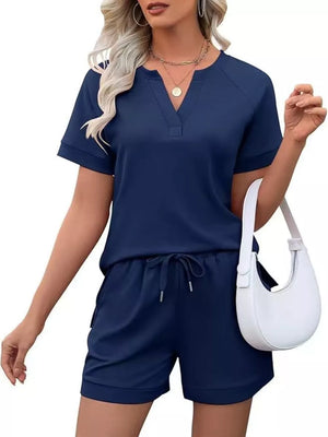 Navy blue relaxed two-piece set with drawstring shorts and v-neck top with pockets.