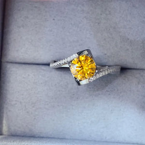 Silver ring with a bright yellow diamond and pave diamond accents in a swirl design.