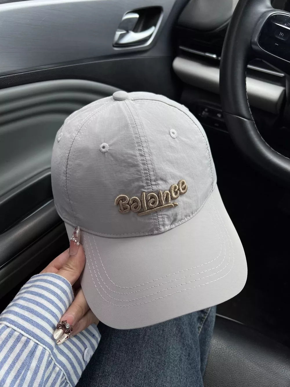 Embroidered balance cotton baseball cap in grey with tan stitching.