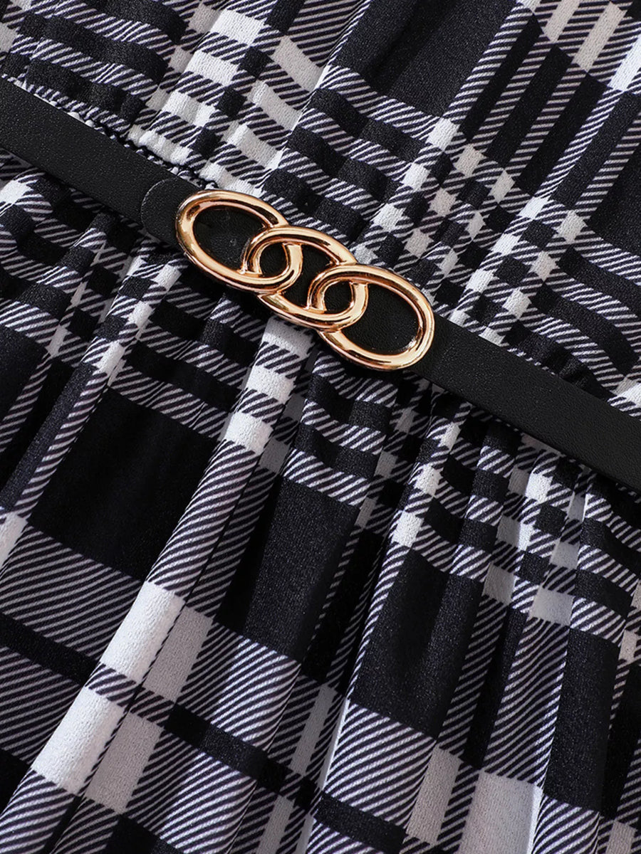 Belted plaid dress in black and white with gold chain detail.