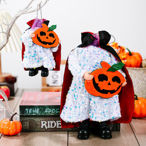Halloween doll in white sequin dress, red cape, holding pumpkin.