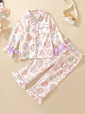 Toddler pink button-down pajama set with pastel egg print and purple trim.