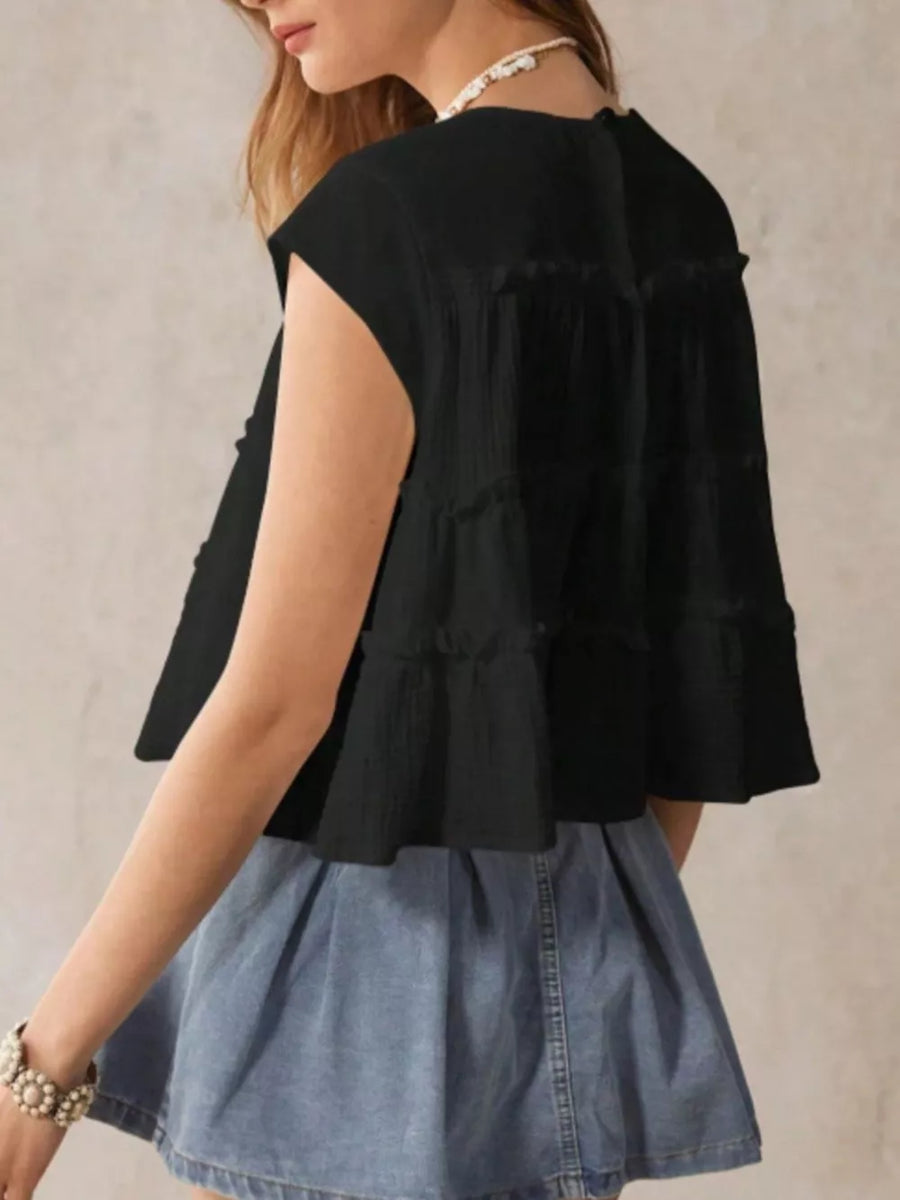 Black tiered ruffle blouse with short sleeves and a relaxed fit.