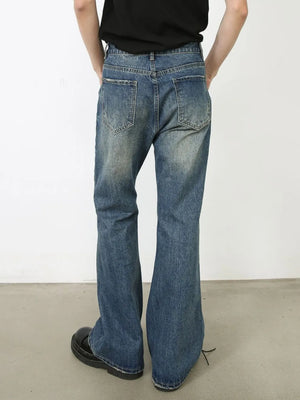 Distressed flare leg jeans in medium wash denim with a buttoned fly and casual styling.