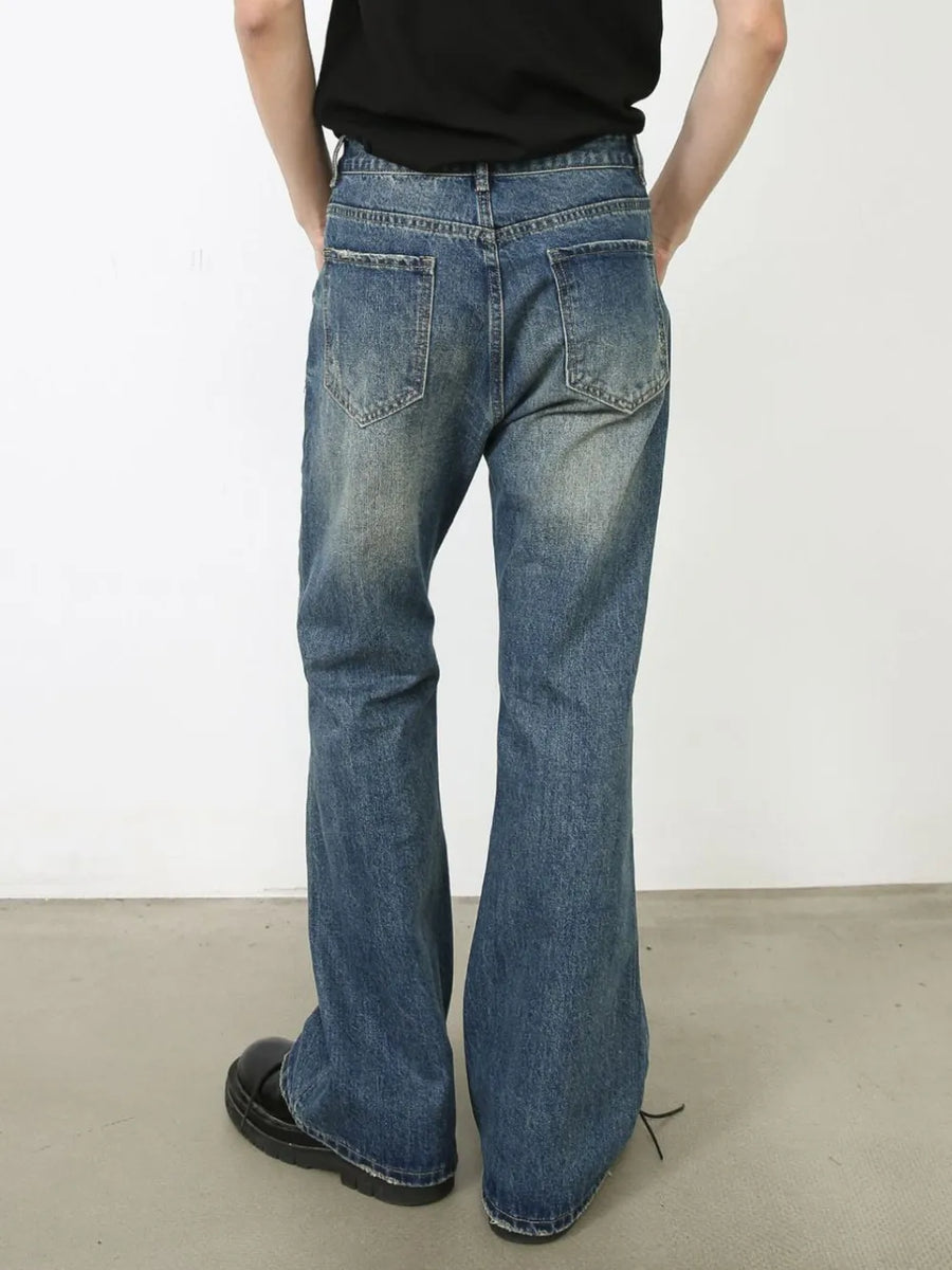 Distressed flare leg jeans in medium wash denim with a buttoned fly and casual styling.