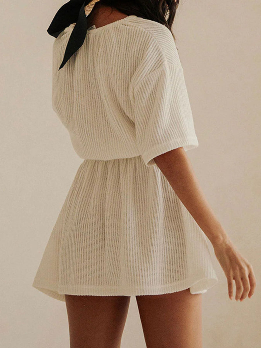 Textured white half sleeve cover-up dress with cinched waist and black neck tie.