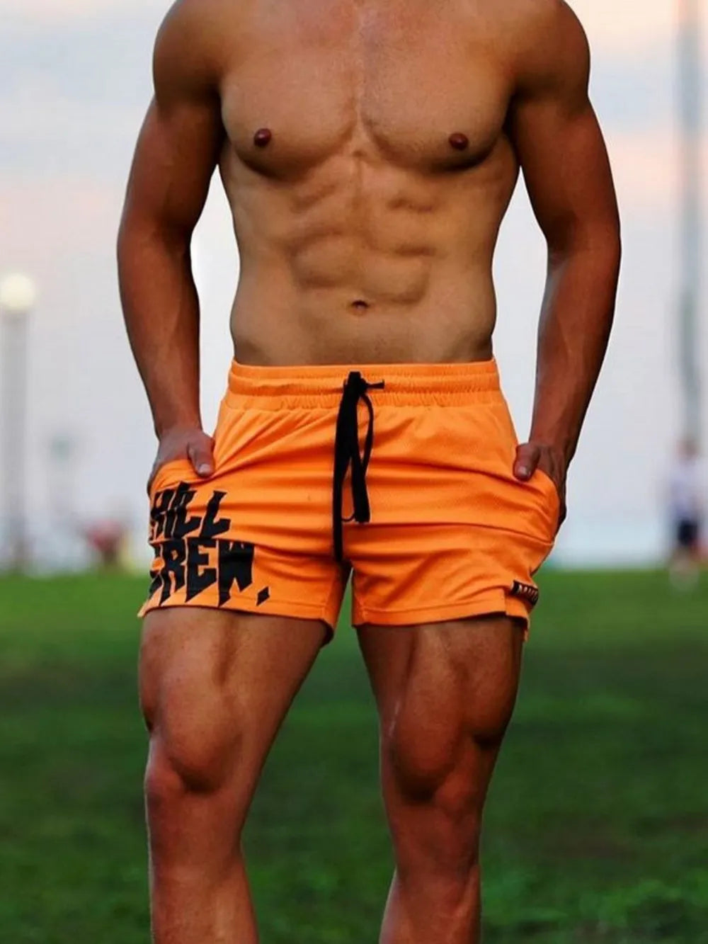 Orange performance shorts with black graphic print and drawstring.