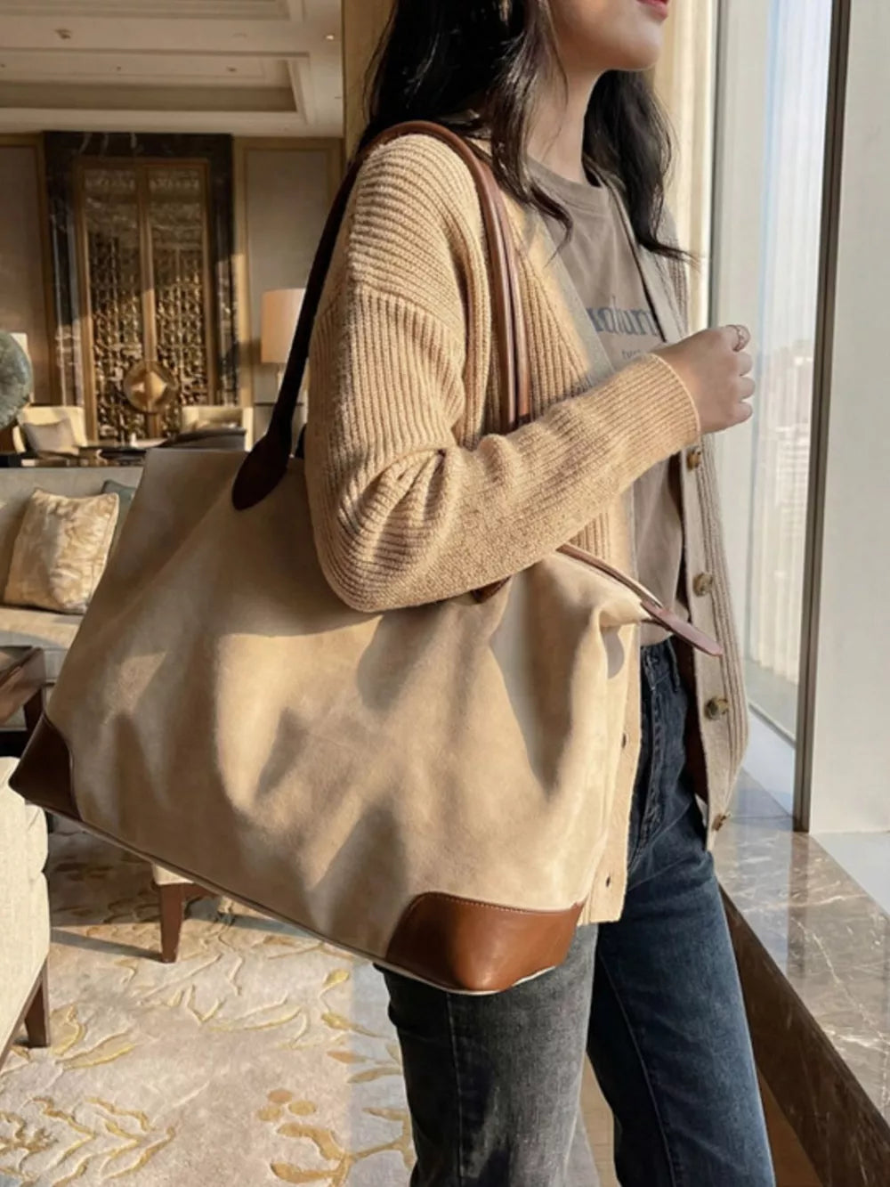 Chic slouchy travel bag in beige suede with camel leather accents and top handles.