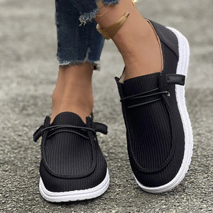 Black corduroy boat shoes with lace detail and white soles.