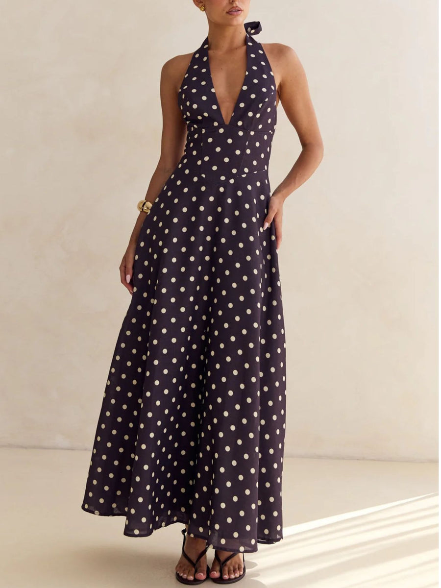 Maxi dress with halter neck, deep V-neck, and polka dot pattern.