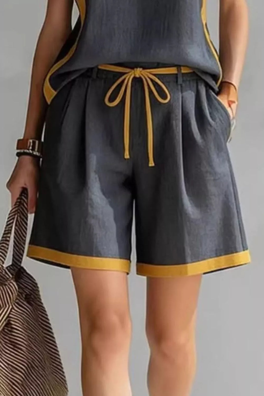 Dark gray shorts set with yellow contrast trim and drawstring waist, featuring a tank top and pleated shorts.