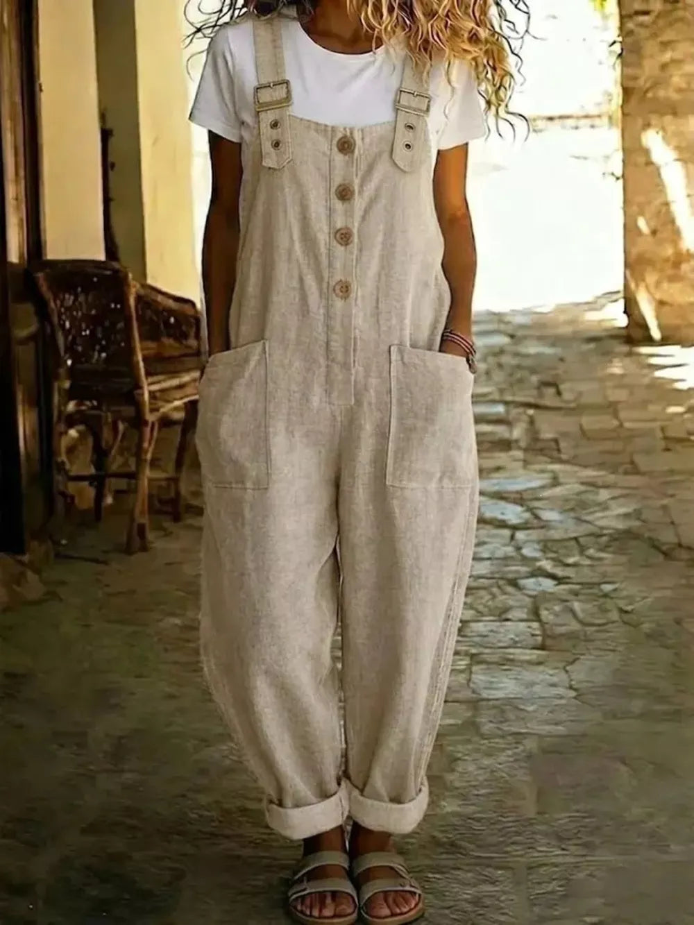Rustic-button wide leg romper with pockets in beige, featuring adjustable straps and a button front.