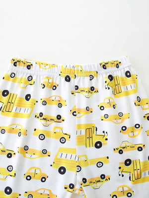 Toddler pajama set with yellow cartoon car print on white fabric, elastic waistband.