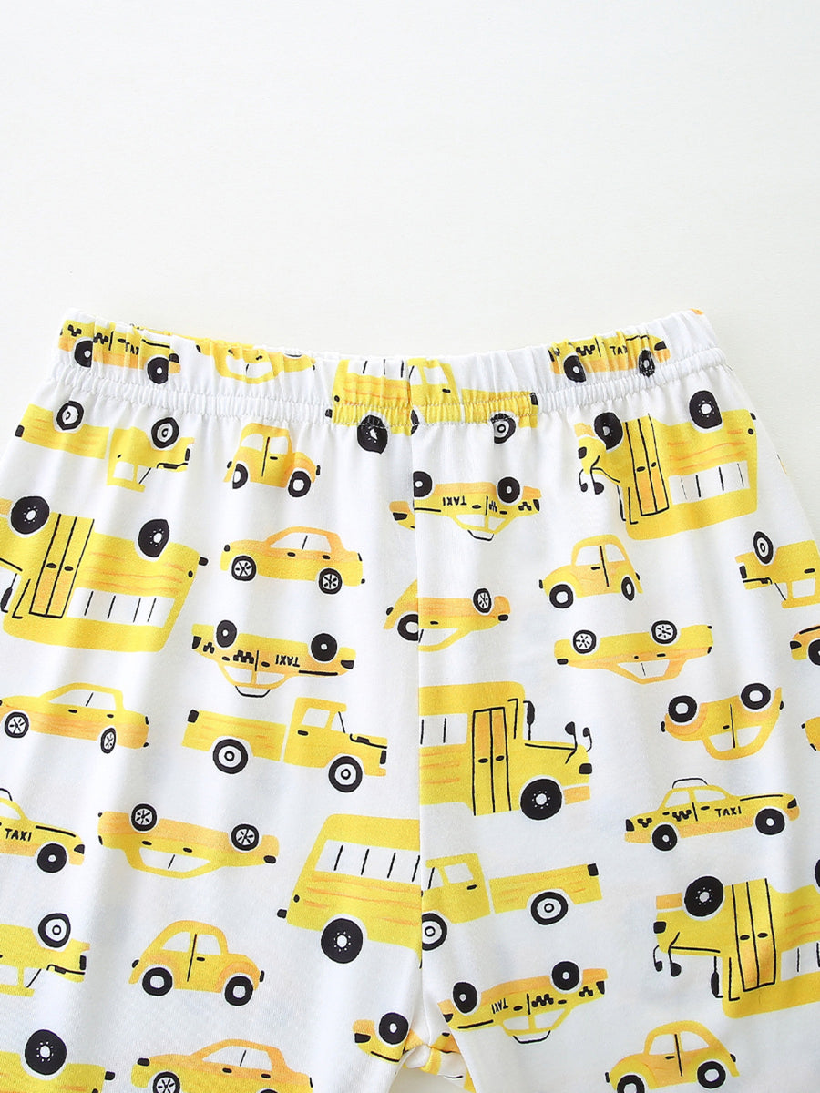Toddler pajama set with yellow cartoon car print on white fabric, elastic waistband.