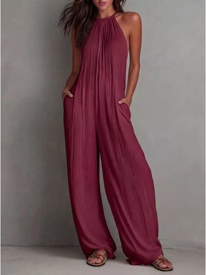 Red wide-leg jumpsuit with halter neck and textured fabric.