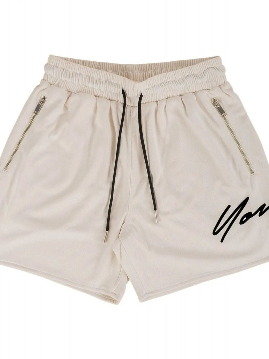 Beige BigFit jogger shorts with drawstring, zip pockets, and black script logo.