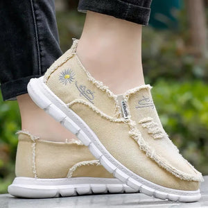Khaki canvas slip-on shoes with raw edges and embroidered daisy detail.