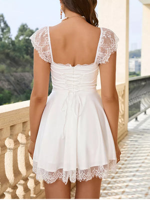 White lace-embellished mini dress with square neck, cap sleeves, corset back and lace hem.