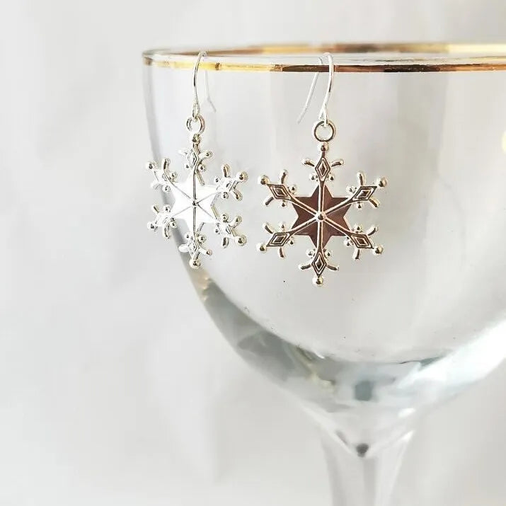 Silver snowflake drop earrings with intricate detailing.