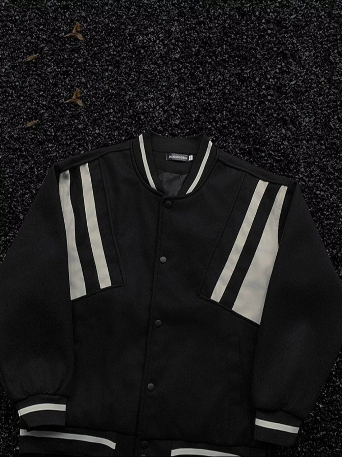 Black bomber jacket with white stripe accents on sleeves and collar, buttoned front.