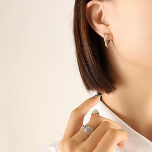 Silver wide triangle huggie earrings made of steel.