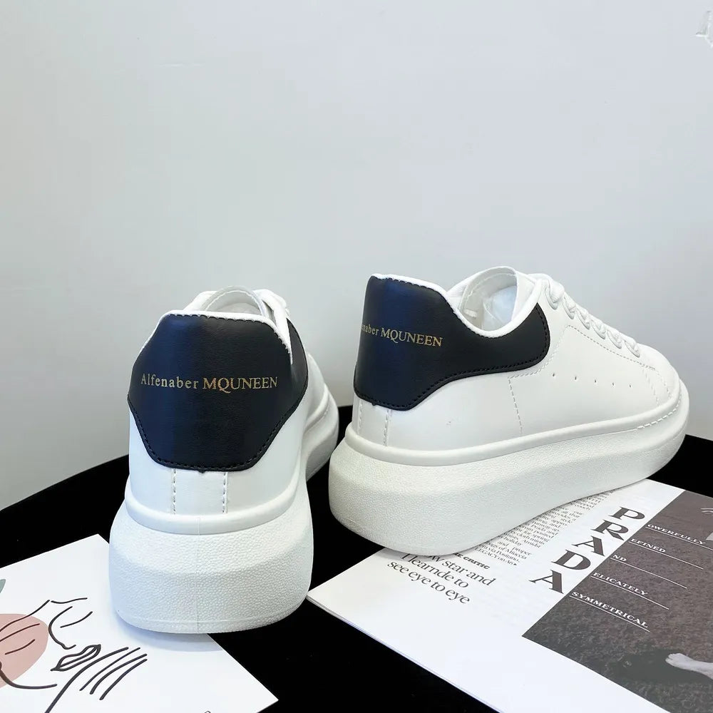 White platform sneakers with black suede heel detail and gold lettering.