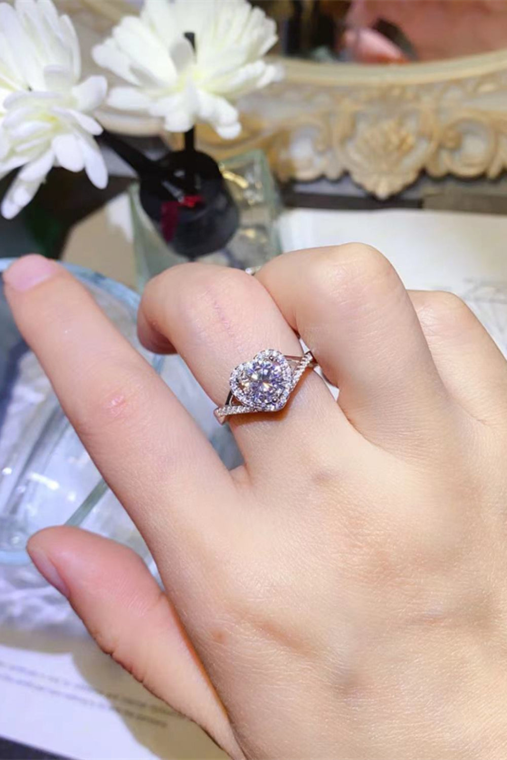 Silver heart halo moissanite engagement ring with pave band.