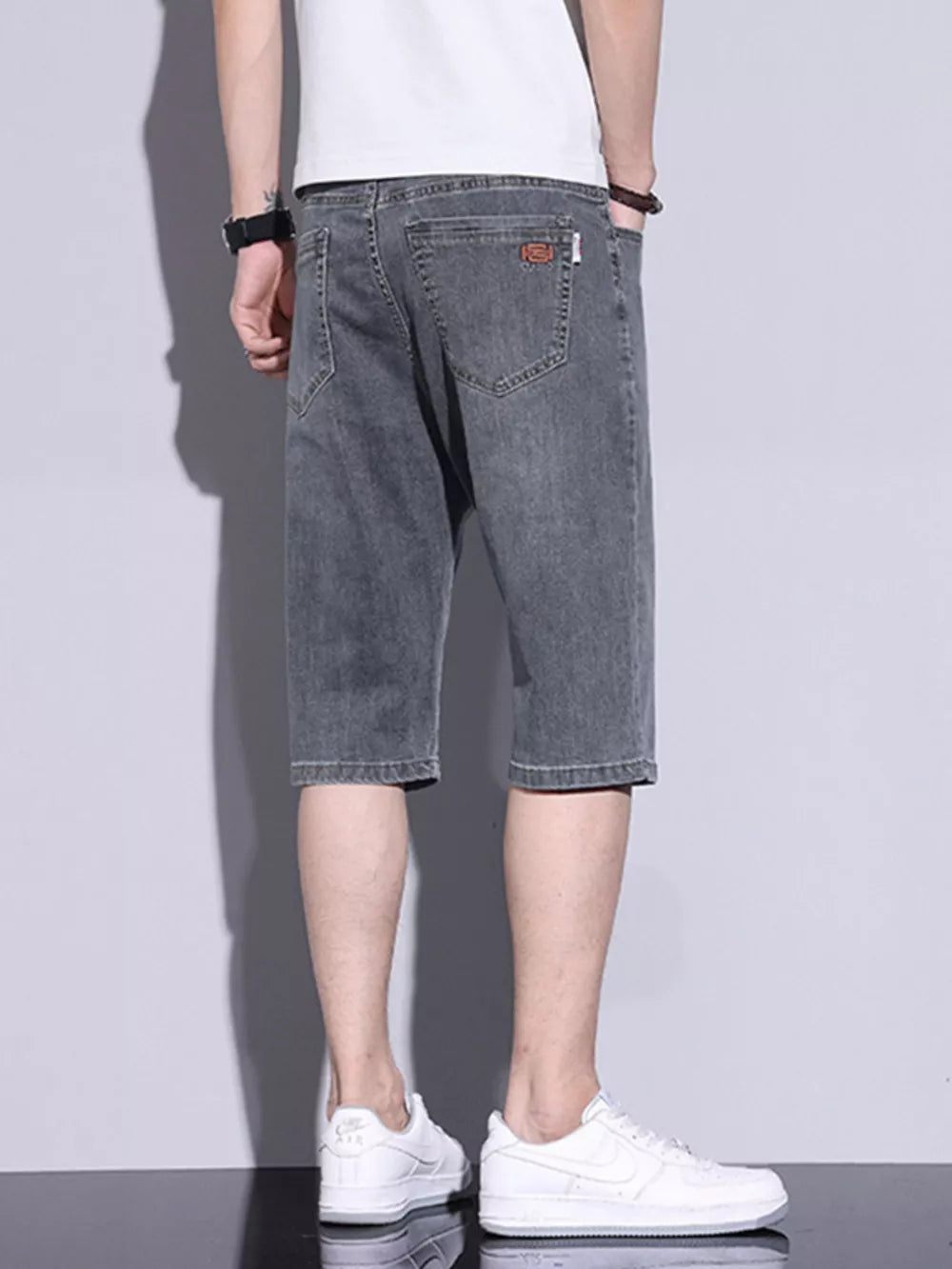Men's grey washed denim shorts with button closure and classic five-pocket styling.