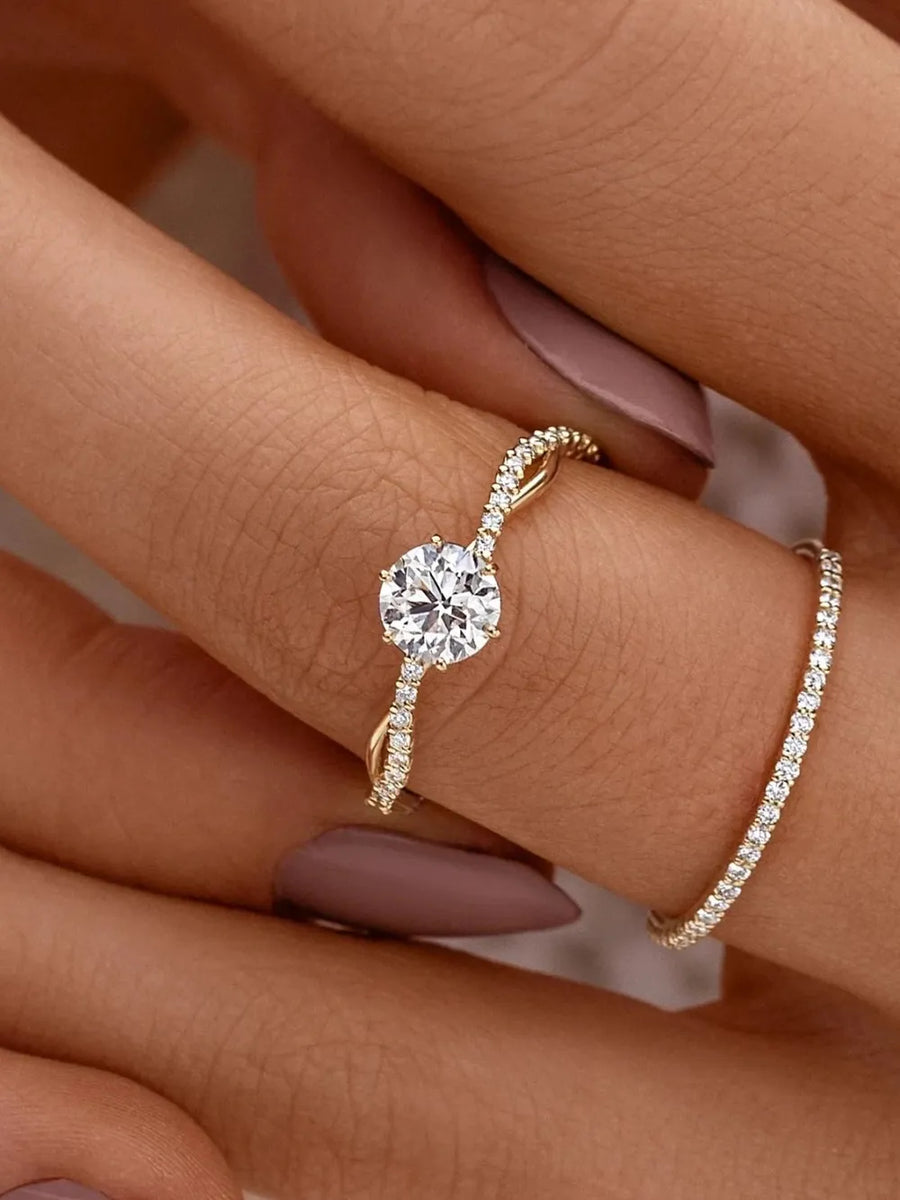 Gold twisted pavé zircon engagement ring with a round center stone.