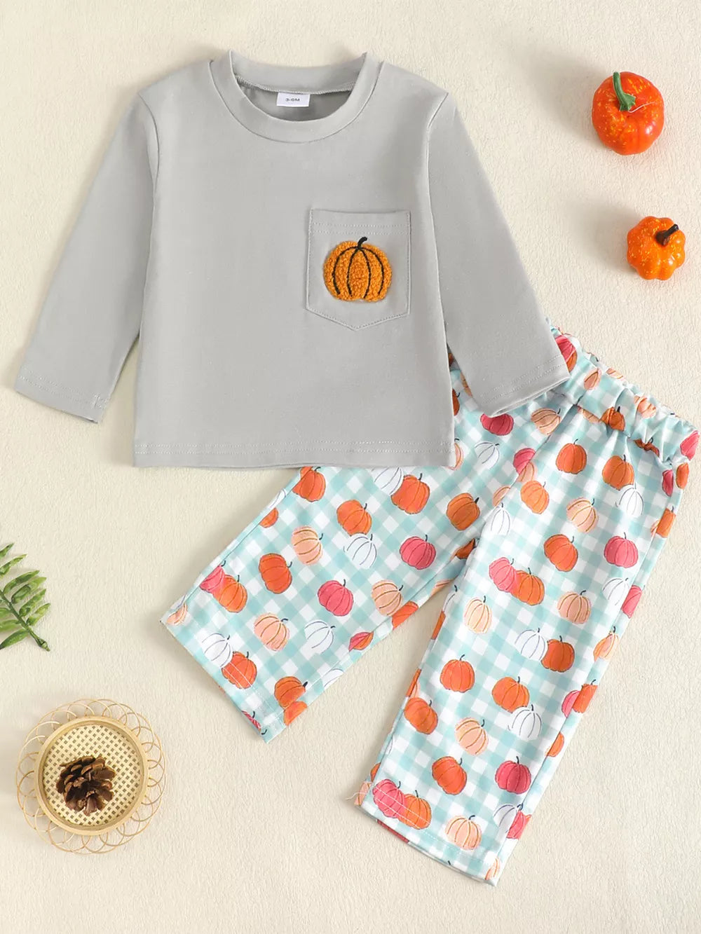Gray long sleeve baby top with pumpkin pocket and pumpkin print pants.