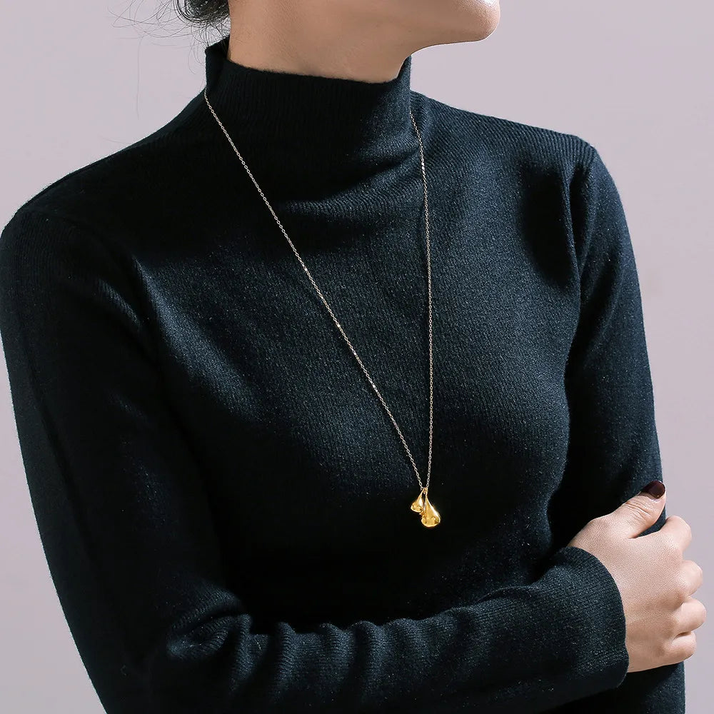 Gold pendant necklace with sculptural, polished teardrop charms on a delicate chain.