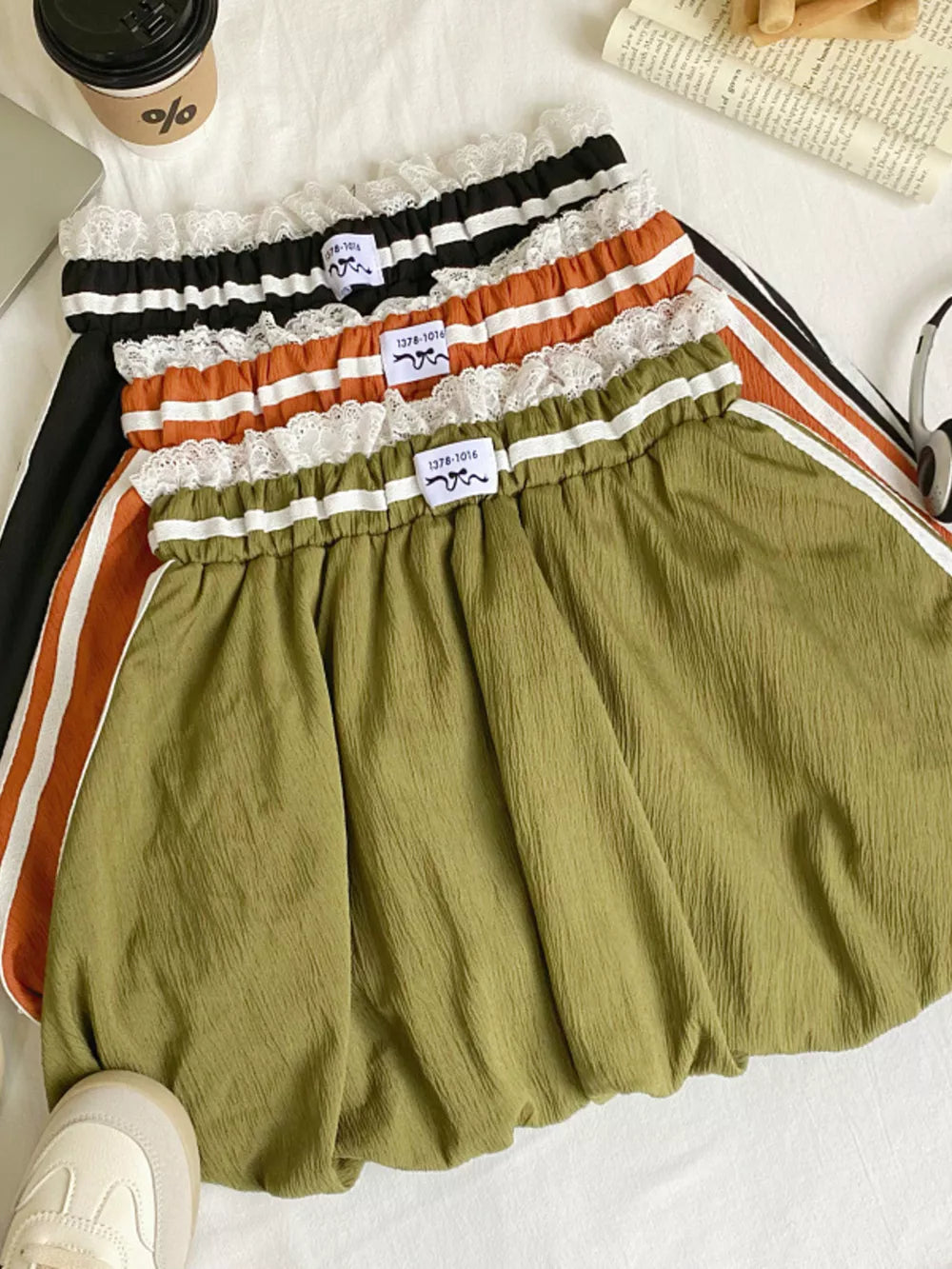 Lace-trimmed gathered waist mini skirt in army green with white stripe detail.