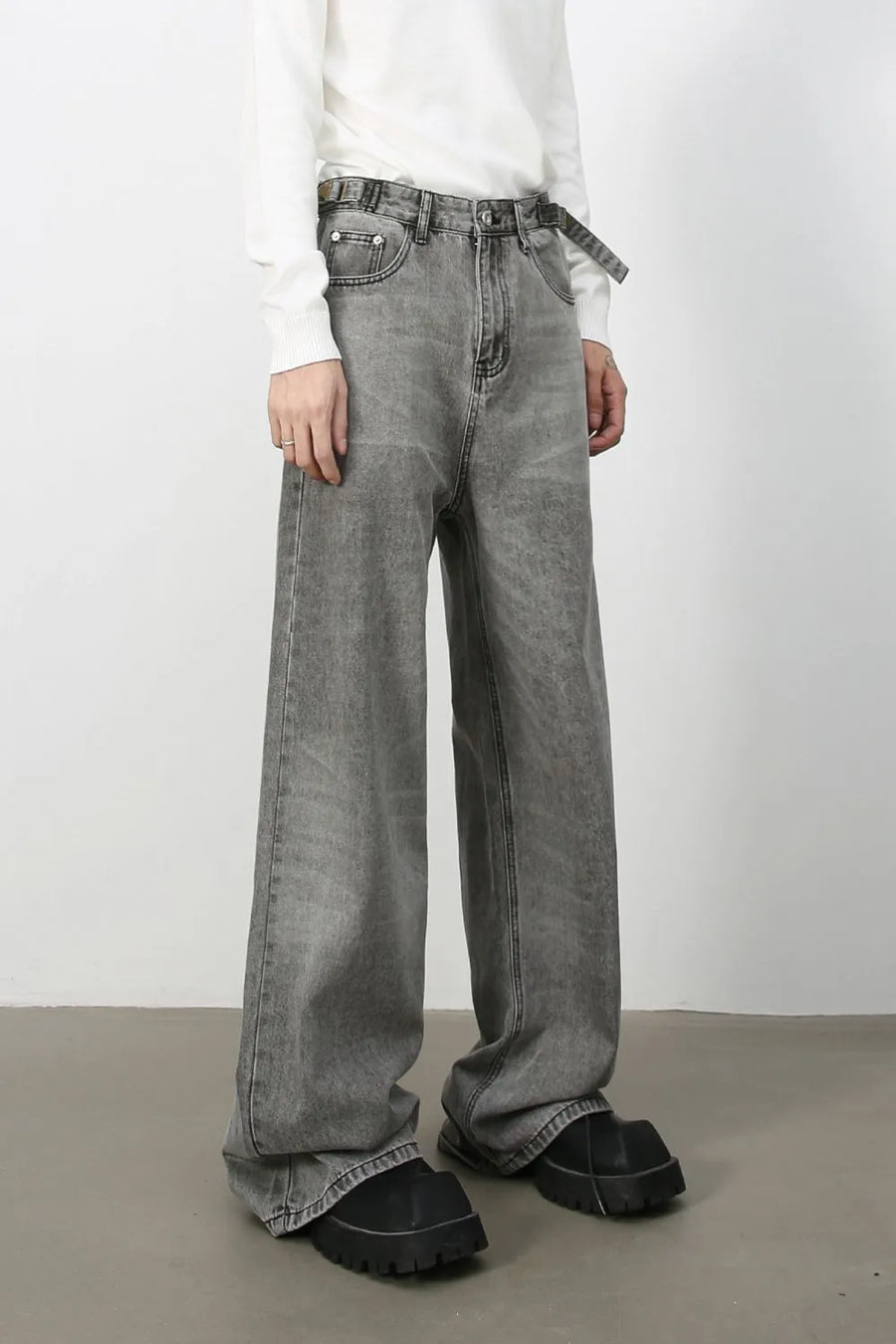 Wide-leg dark gray washed denim jeans with belt and a relaxed fit.