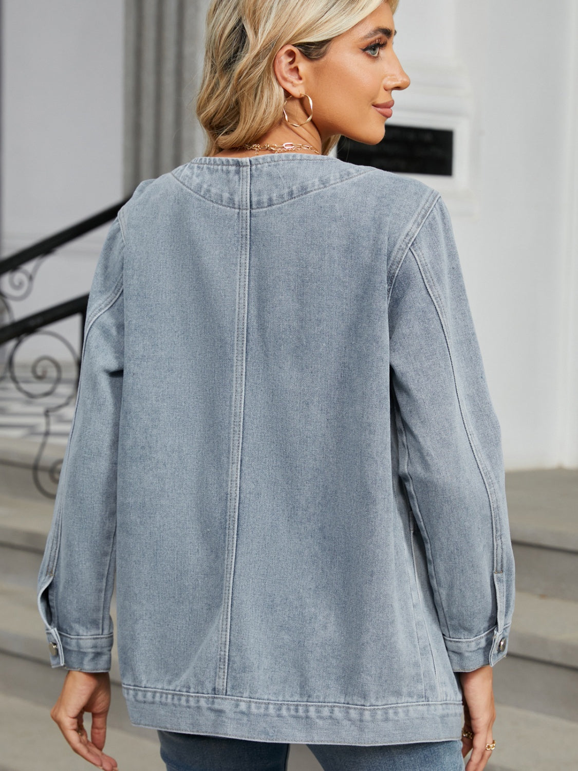 Light blue denim blazer with buttoned cuffs and a classic collarless neckline.