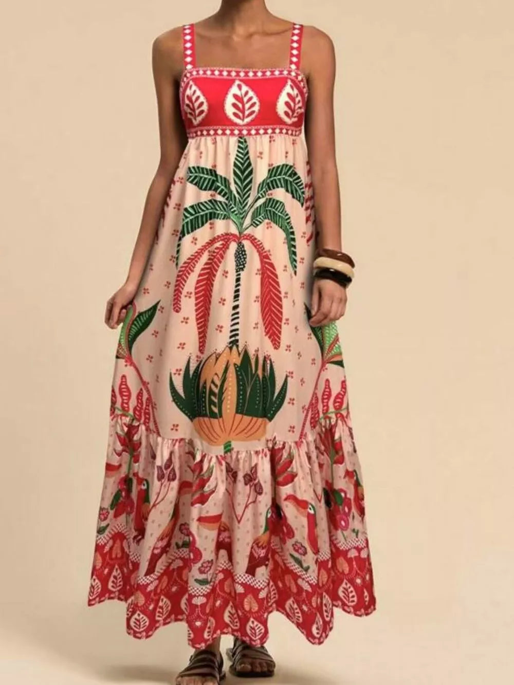 Tropical maxi dress with square neck, palm tree and bird print, tiered hem, and red yoke detail.