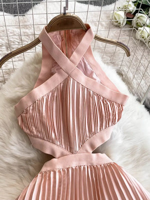 Pink pleated maxi dress with halter neckline and cutout details.