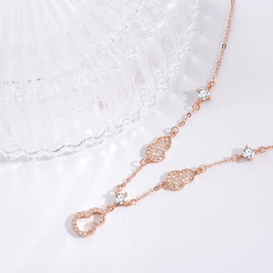 Rose gold Y-lariat necklace with zircon-adorned gourd charms and cubic zirconia.