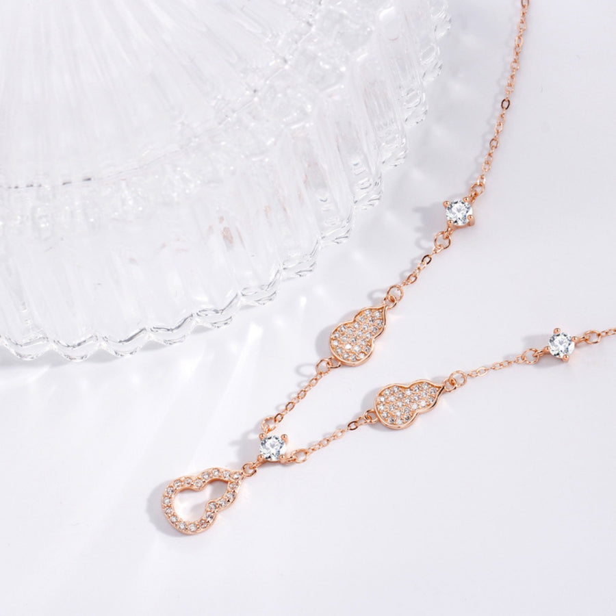 Rose gold Y-lariat necklace with zircon-adorned gourd charms and cubic zirconia.