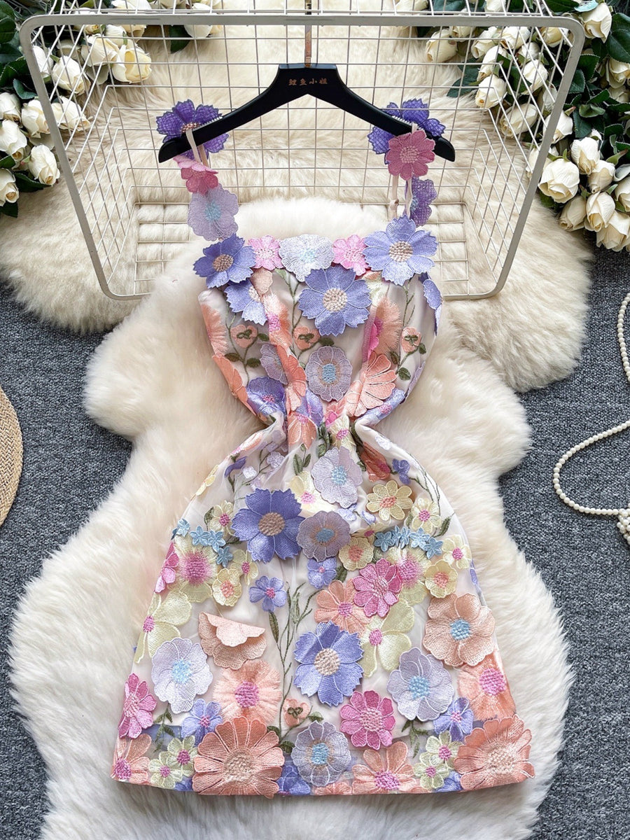 Embroidered floral mini dress with applique flowers in purple, pink, yellow, and orange on a sheer fabric.