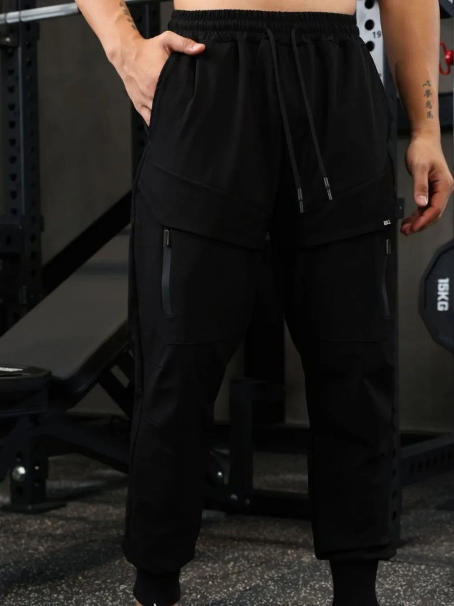Black technical joggers with zip pockets and drawstring waist.