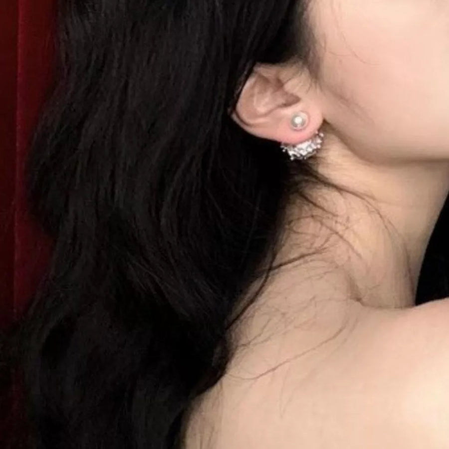 Pearl stud earrings with a sparkling crown-inspired back detail.