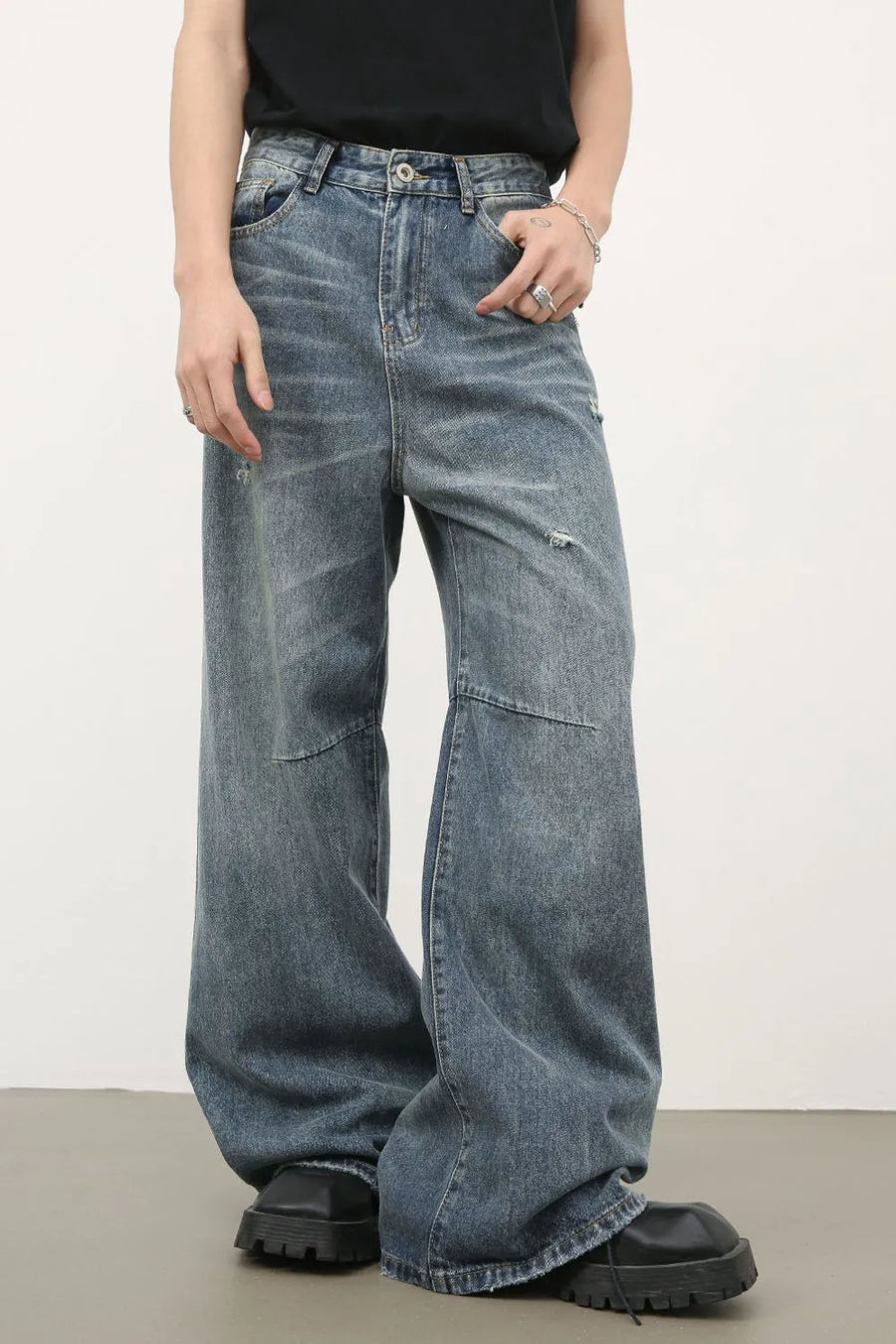 Distressed edge wide-leg jeans in medium wash denim with a relaxed fit.